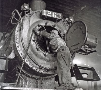 Man servicing a locomotive.