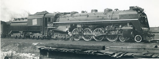 Black and white image of steam locomotive No. 6213 with a tender piled high with coal. 

