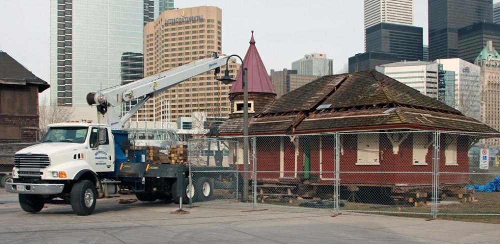 A reassembled Don Station at the Toronto Railway Museum. A truck with a lift arm is pictured next to the station.