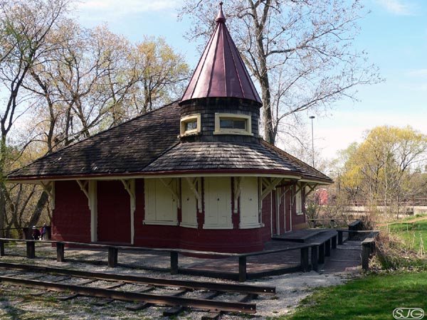 Don Station before the restoration. The station is surrounded by a low wooden fence and a piece of railway track sides on the ground next to it.