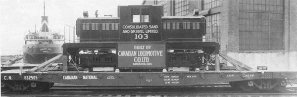 Historic photo of CLC No. 2637. This locomotive is the same type as No. 1 in the Toronto Railway Museum collection. The locomotive sits on a flat car in front of a warehouse.