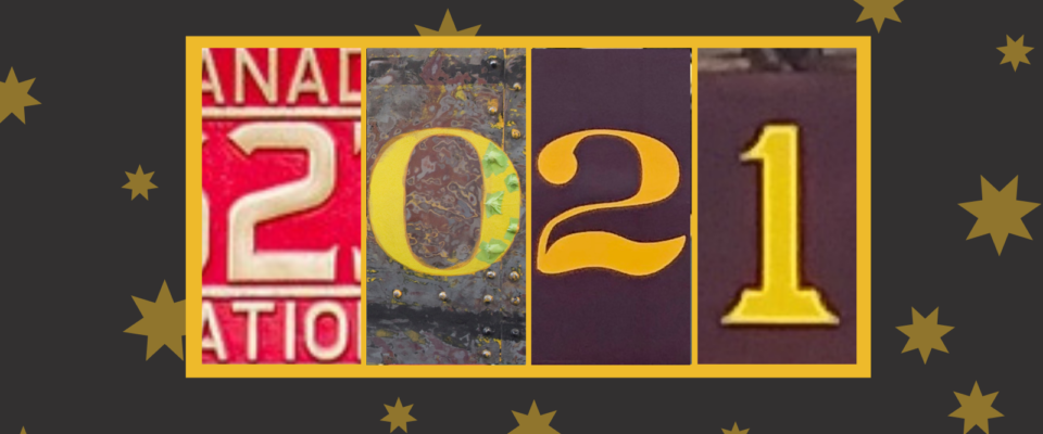 2021 on a grey background with yellow stars. each digit in the year is a close up photo of a piece of rolling stock numbered with that digit