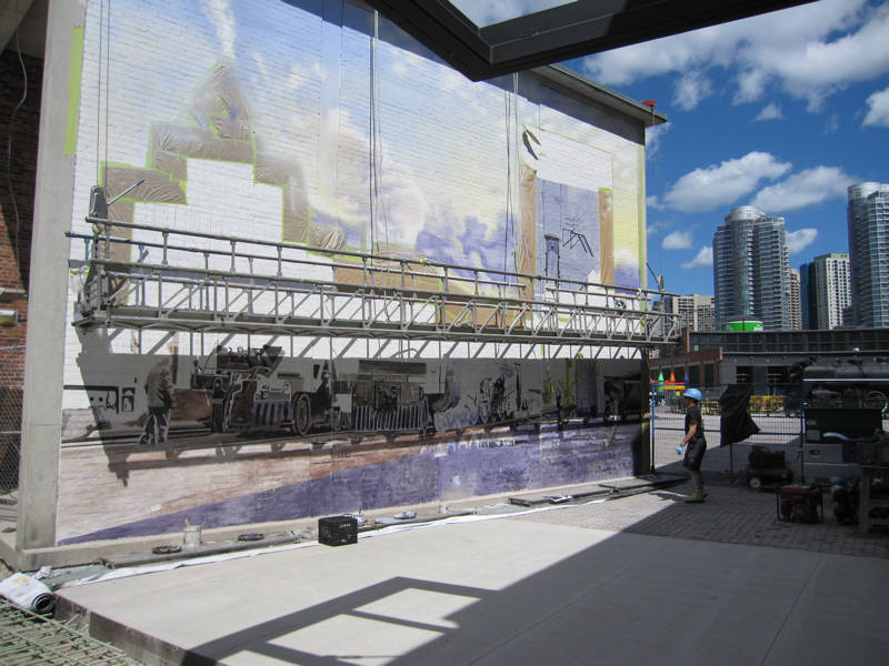 Scaffolding hangs in front of the in-progress mural
