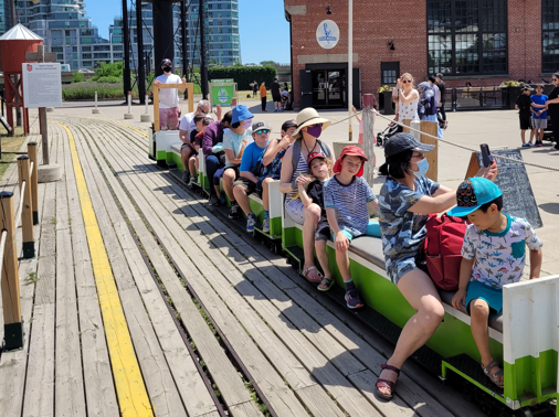 Visitors sit aboard the Mini Train while it is parked at the station.