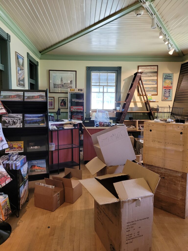 Disorganized museum store space with boxes strewn on the floor
