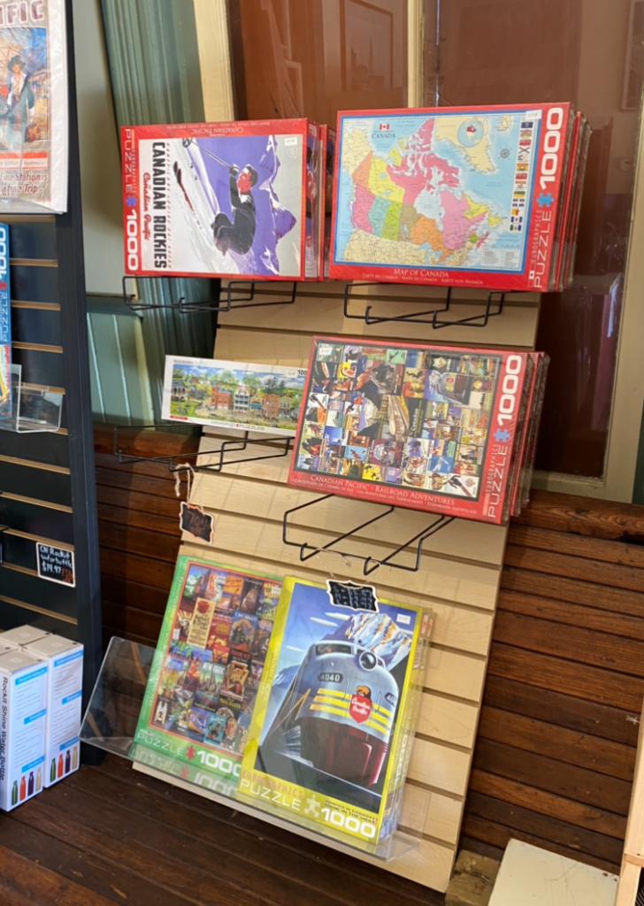 Assorted boxes of jigsaw puzzles on a wire rack in the museum store