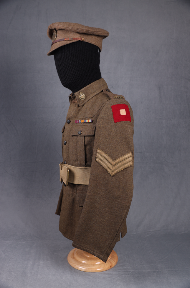 Side view of railway military jacket and hat on a mannequin, showing off a red shoulder patch.