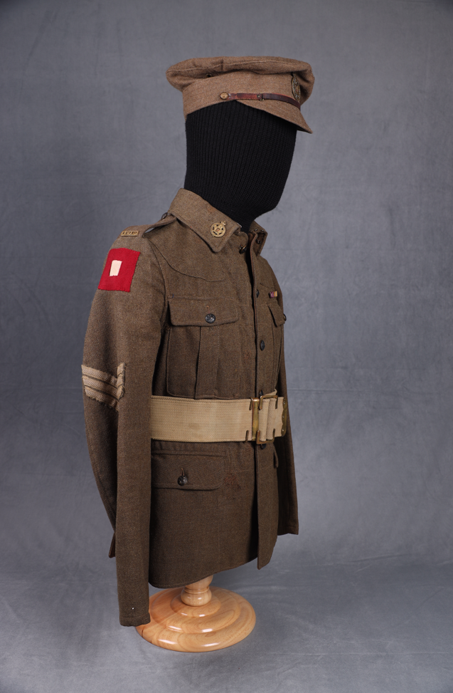 Side view of railway military jacket and hat on a mannequin, showing off a red shoulder patch.