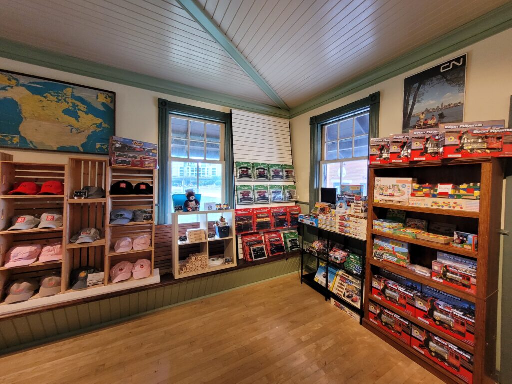 Wooden museum store shelves stocked with train toys and railway hats